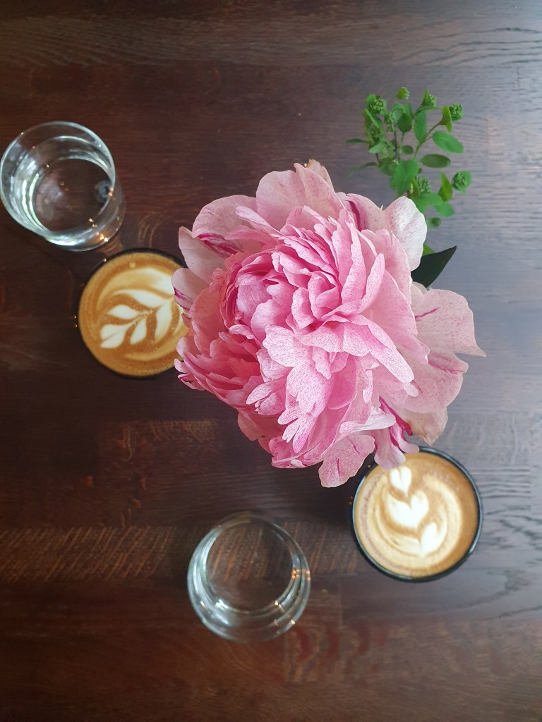 Pöydällä kaksi kuppia Kahiwa Coffee & Wine kahvilan cappuccinoa